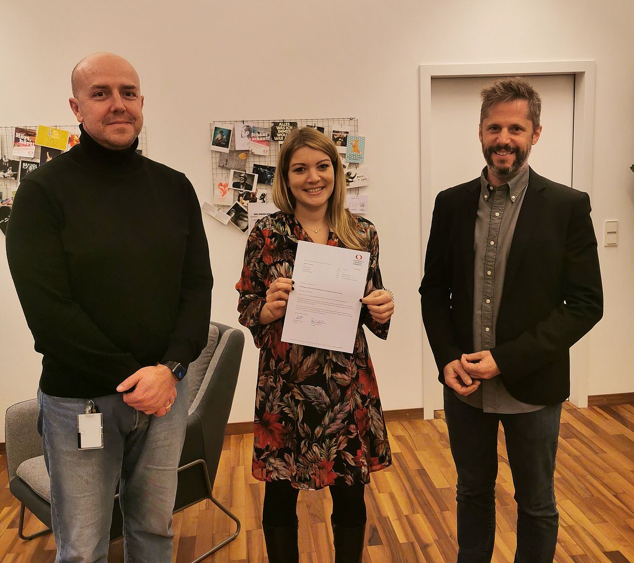 Kanzler Alexander Würth (li.) und Hochschulpräsident Prof. Rainer Kotzian (re.) gratulieren Marina Weber. Sie steht in der Mitte und hält den Brief in den Händen. 