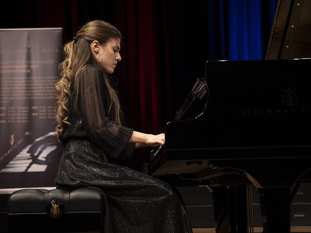 Ioana Voaides sitzt am Flügel und spielt. Perspektive von unten, parallel zur Klaviatur. 