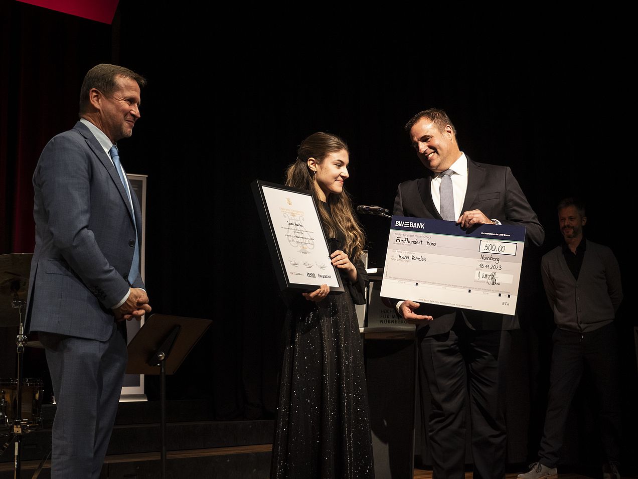 Ioana Voaides steht in der Mitte zwischen Thomas Biller (BW Bank) und Michael Wiesengrund (Piano Haid). Sie hält die Steinway-Urkunde und Thomas Biller den 500€-Scheck in den Händen.