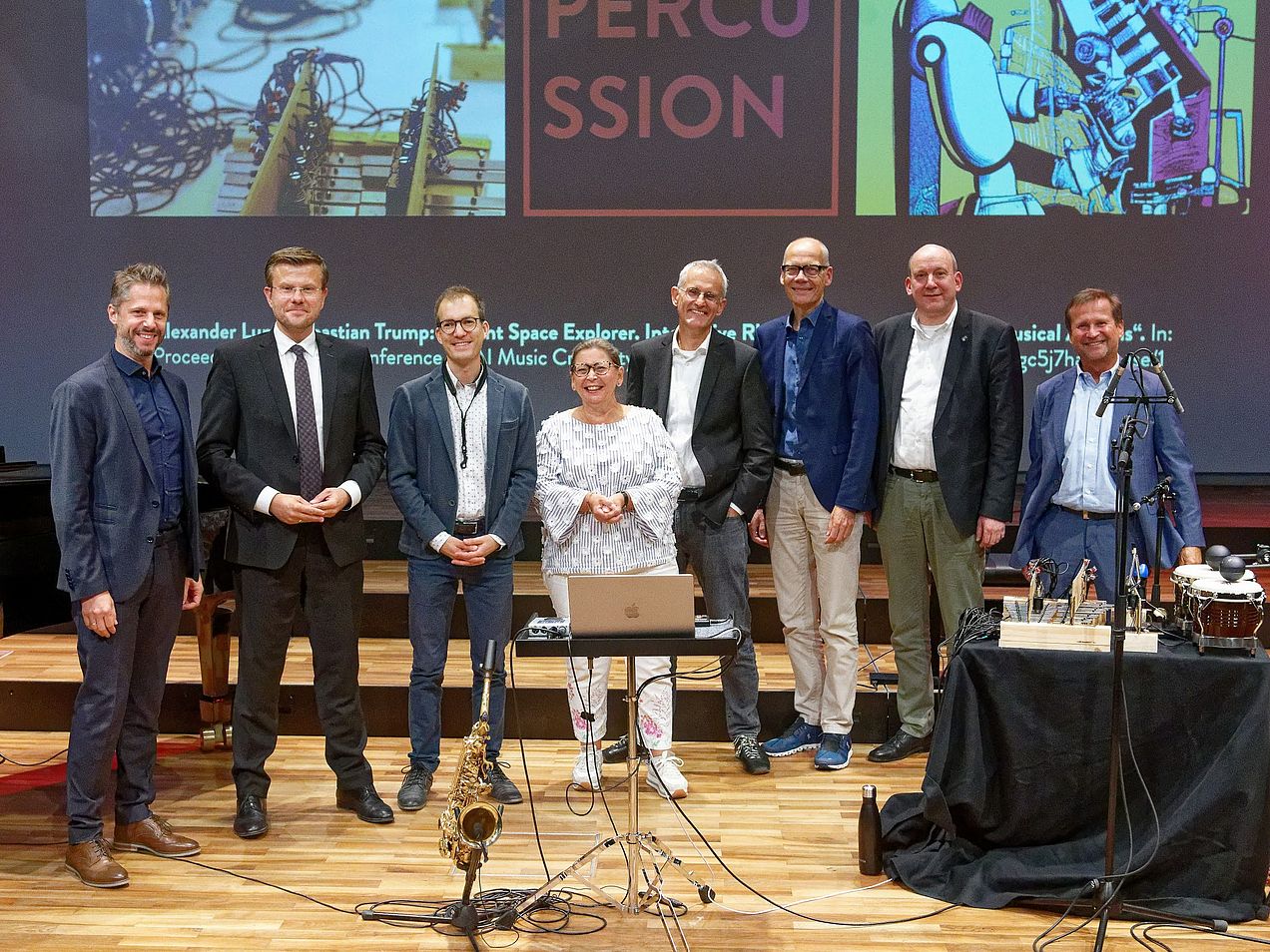 Gruppenfoto der Teilnehmer*innen der Hochschule und dem Oberbürgermeister. Sie stehen in einer Reihe auf der Bühne des Orchestersaals. 