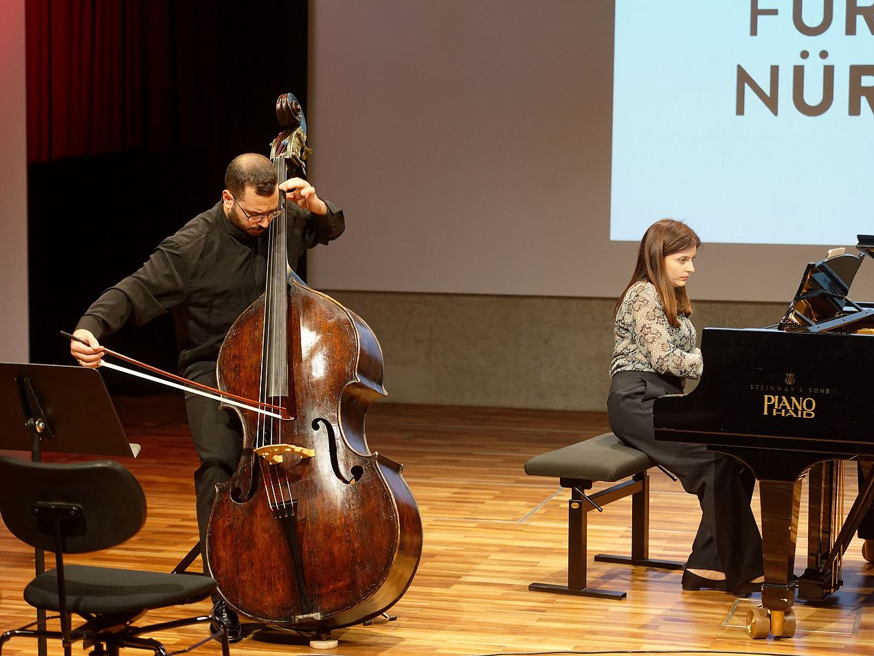 Michail-Pavlos Semsis spielt Kontrabass und Edita Hakobyan begleitet ihn am Flügel auf der Bühne des Orchestersaals. 