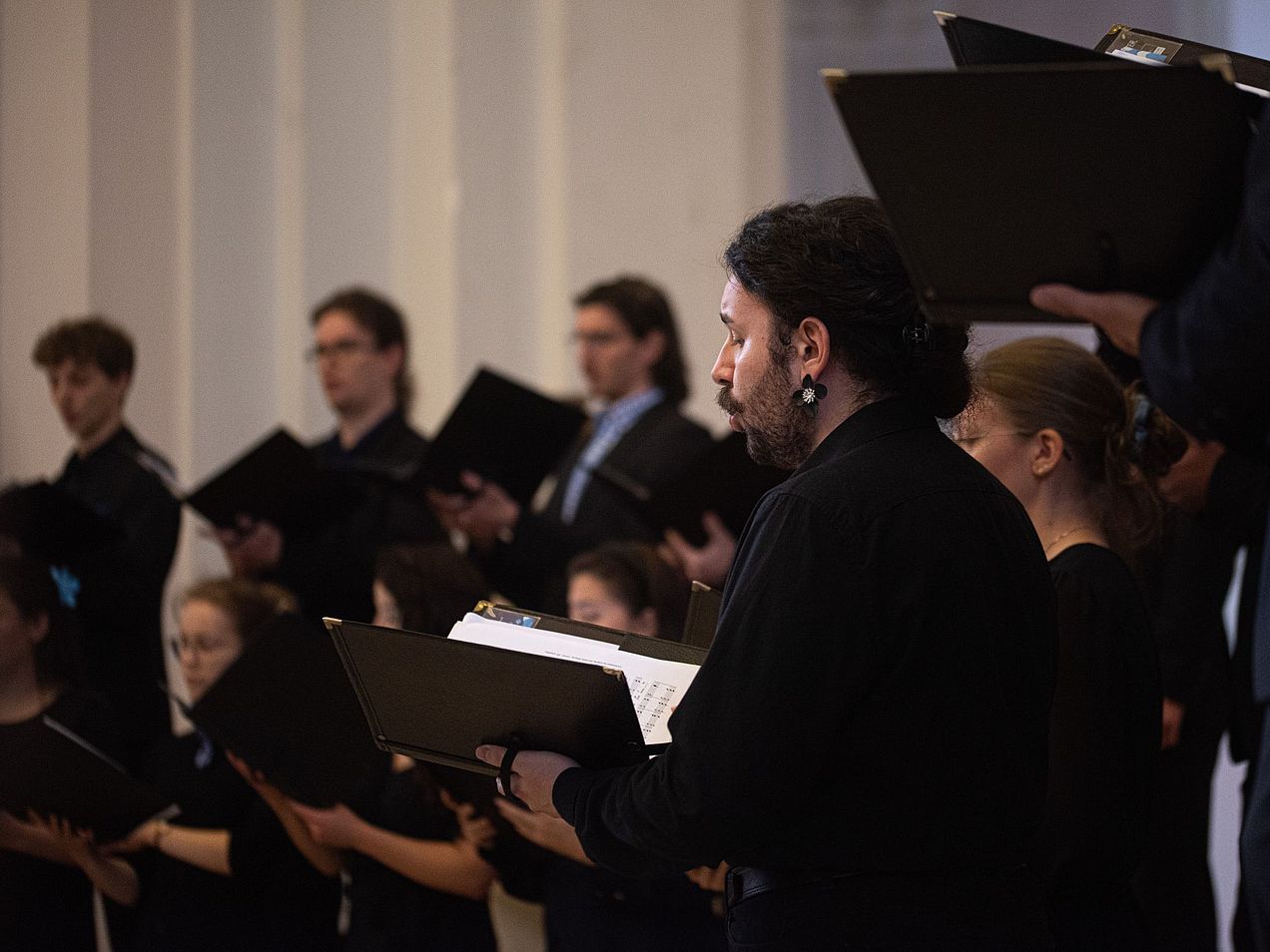 Chormitglieder mit Mappe in den Händen beim Auftritt