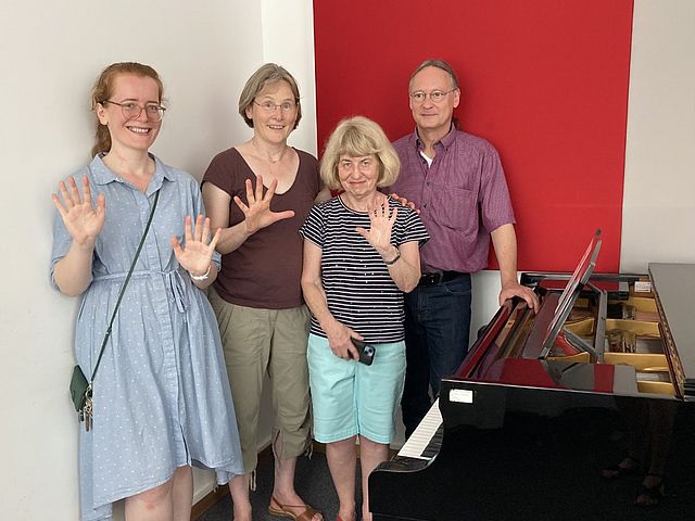  Prof. Dr. Aurelia Visovan, Prof. Ulrike Wohlwender, Rhonda Boyle und Prof. Ulrich Hench stehen im Übungsraum der Hochschule für Musik Nürnberg vor dem Steinway Flügel mit Sirius 6.0 Klaviatur. 