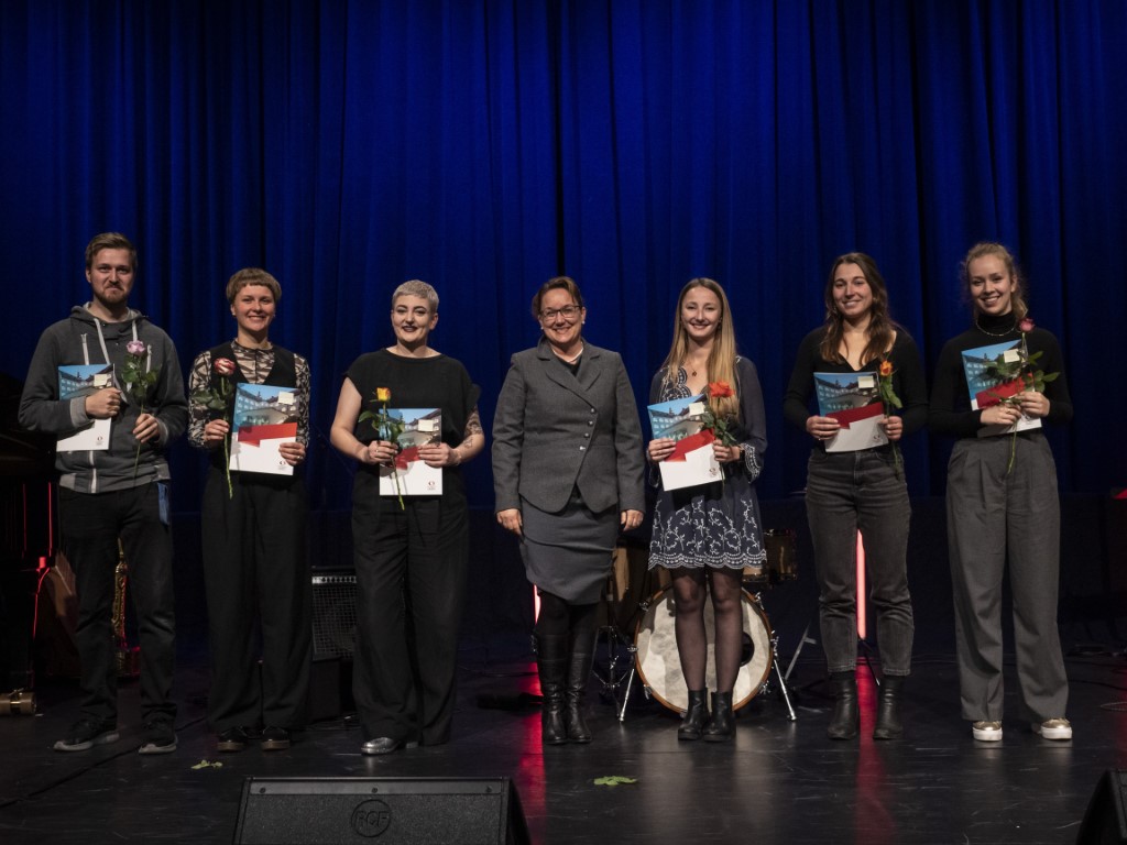 Gruppenbild der Preisträger*innen der Musikpädagogischen Preise, die ihre Zeugnisse in den Händen halten. In der Mitte steht Vizepräsidentin Prof. Dr. Renate Reitinger. 